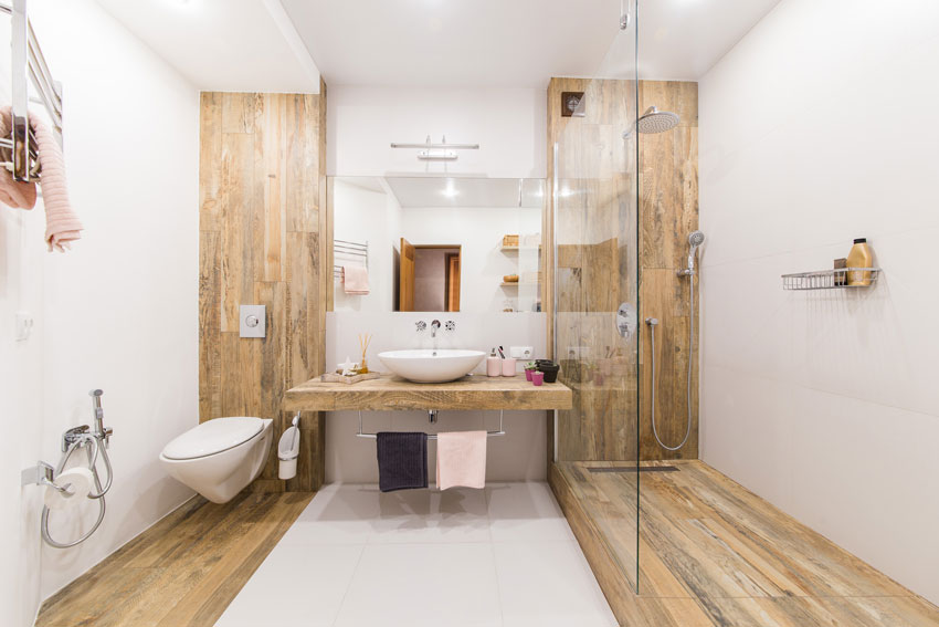 Bagno piccolo ben arredato in lunghezza, rivestimento effetto legno.